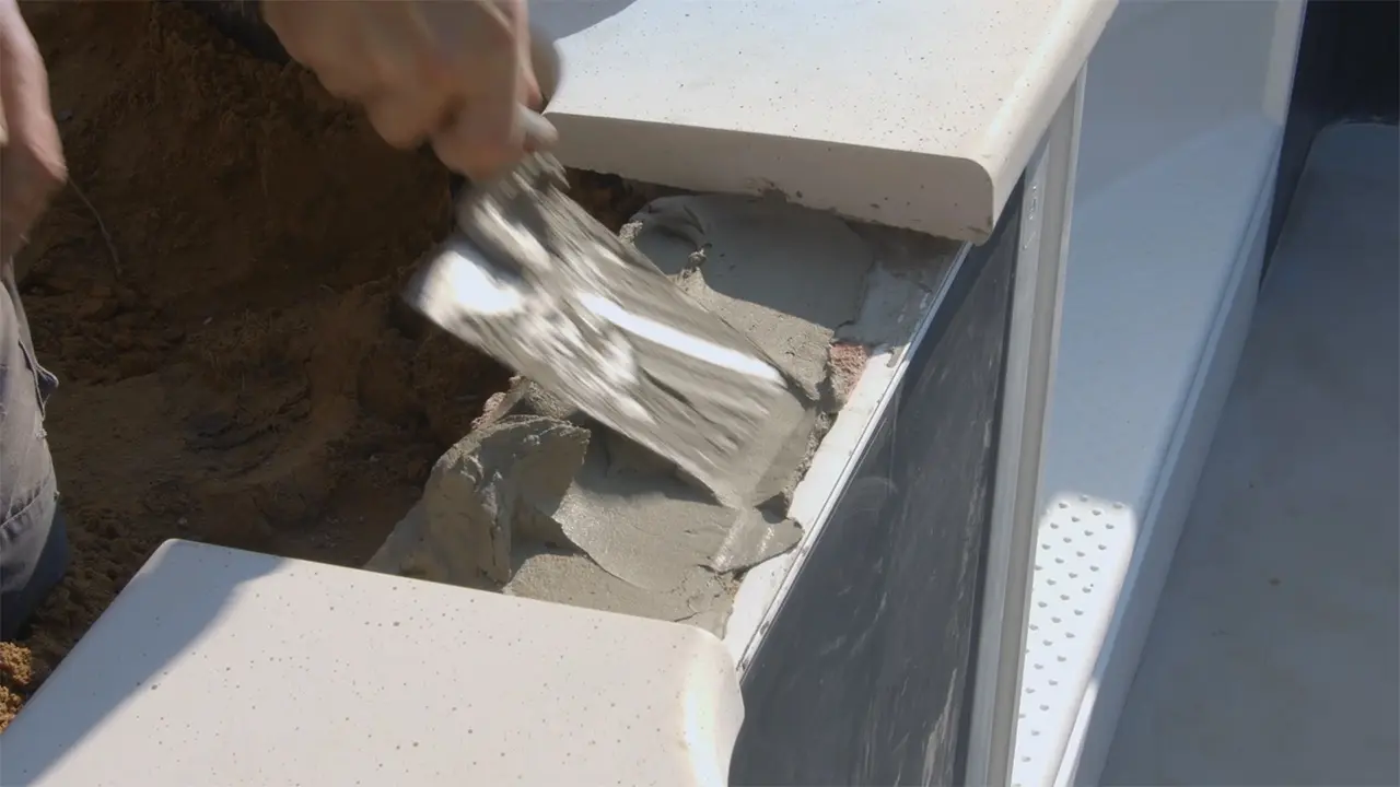 Kleber mit Zahspachtel auf Arbeitsfläche am oberen Ringanker des Pools anbringen