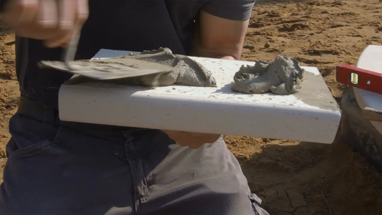 Kleber mit Zahspachtel auf Pool Randstein auftragen