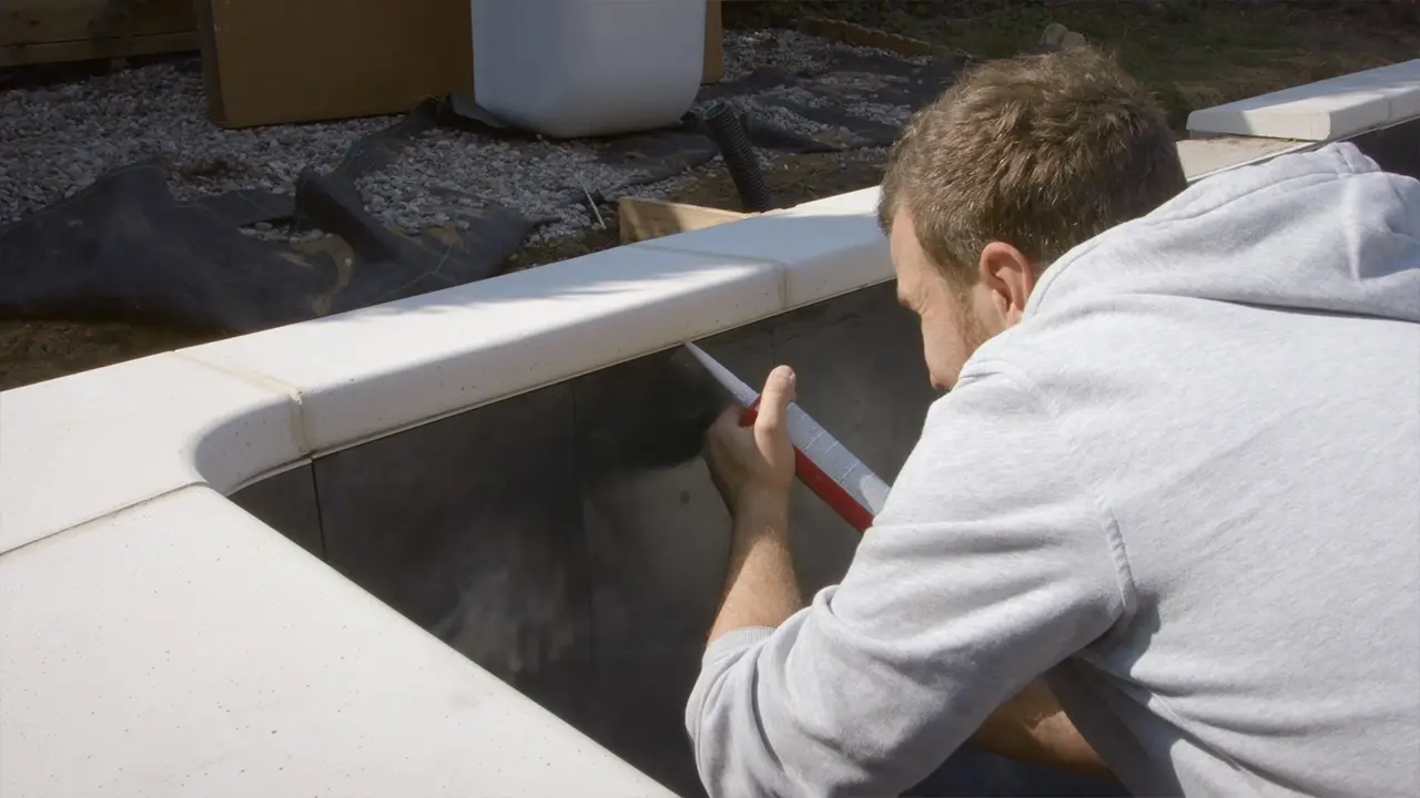Silikon zwischen Pool Randsteinen und Einhängeprofil füllen und glattstreichen